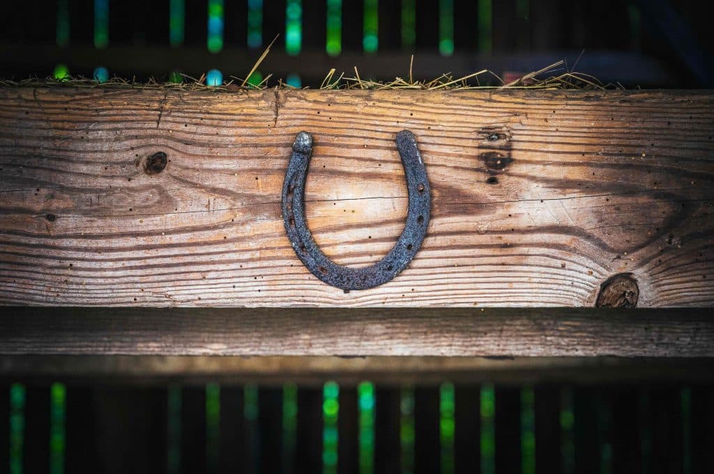A lucky horseshoe nailed onto a beam in a barn.