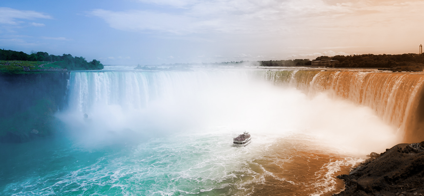 An iridescent view of the Niagara falls with a boat on the water