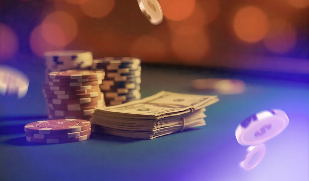 Poker chips and a stack of cash on a table with blurred background and flying chips in mid-air.