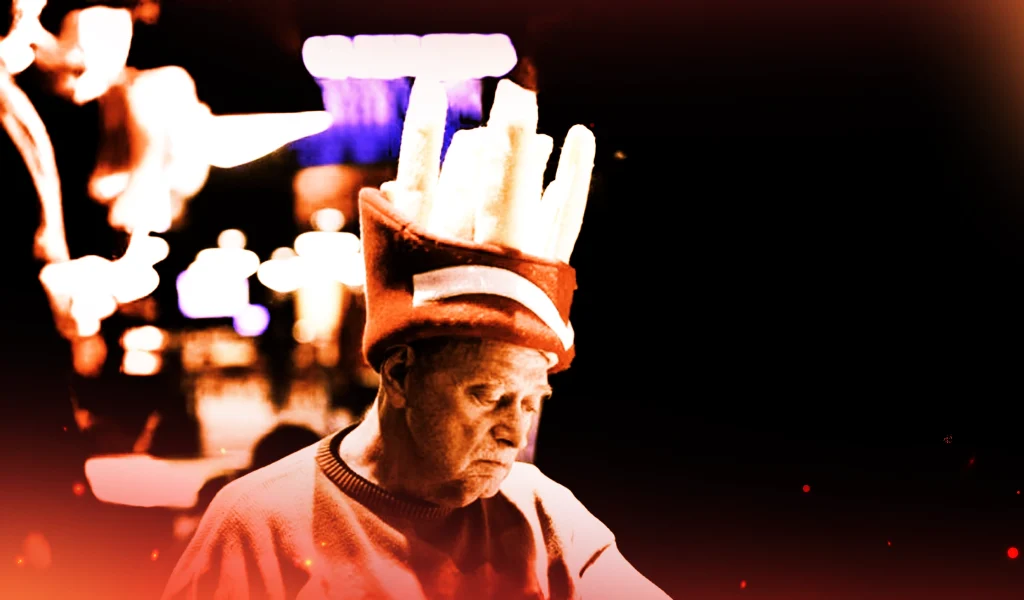 Artie Cobb at the poker table wearing a red hat shaped like a carton of French fries, looking focused.