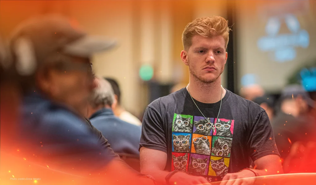 Landon Tice wearing a cat-print T-shirt focused at a poker table during a tournament.