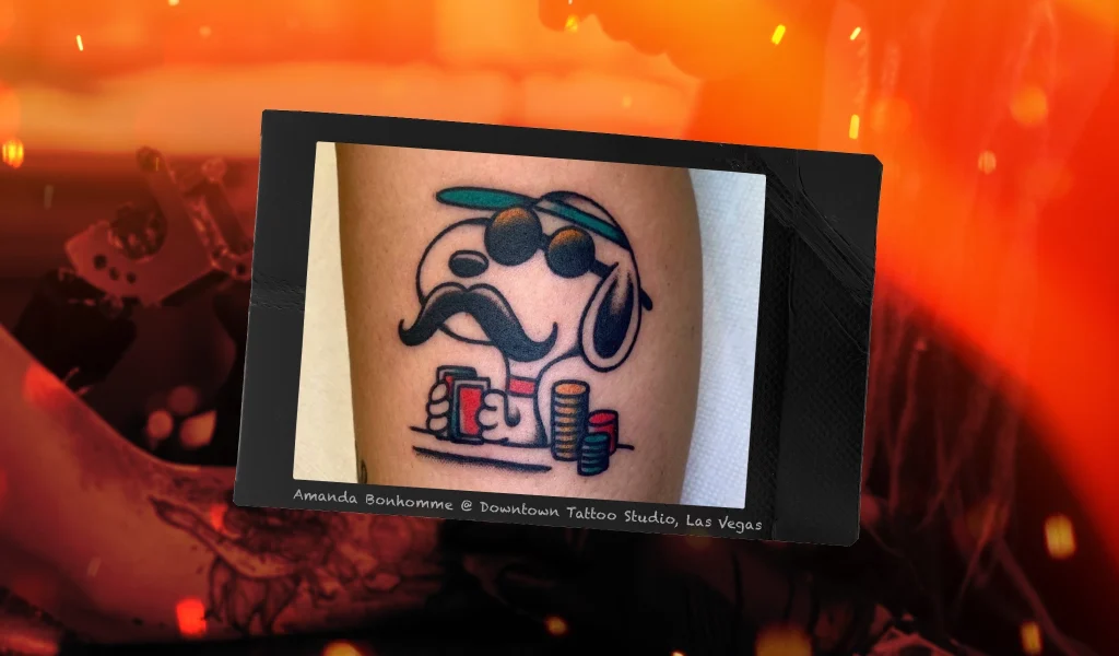 A playful tattoo of a cartoon dog with a mustache and sunglasses, holding playing cards and sitting at a poker table.