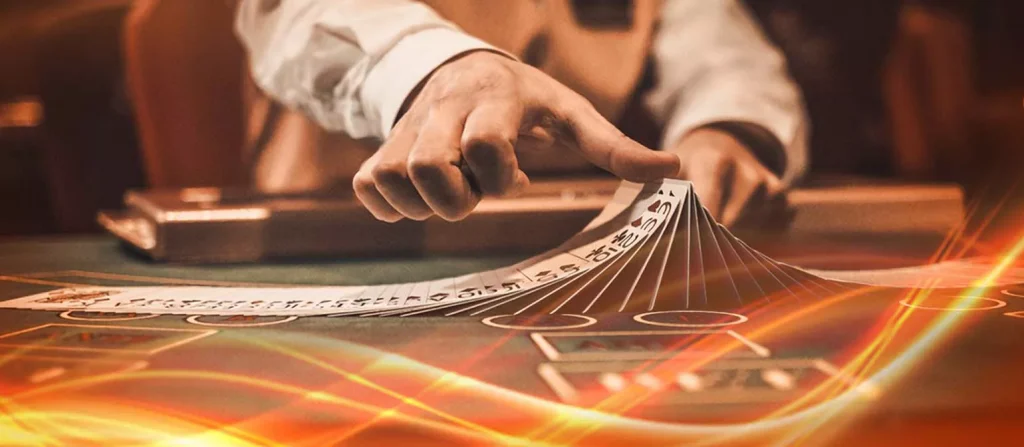 Dealer's hand fanning out playing cards on a glowing casino table with dynamic orange light streaks