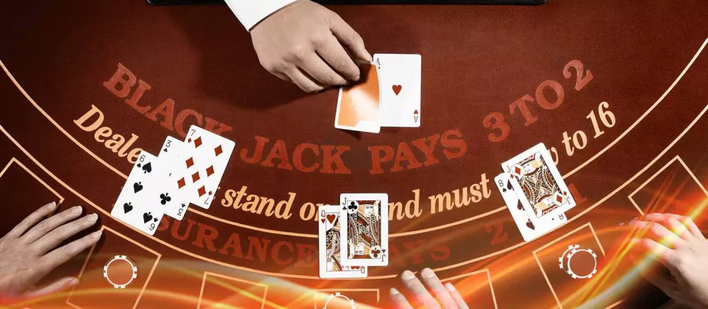 Blackjack table with the dealer drawing a card, hands of three players visible , and the text 'BLACKJACK PAYS 3 TO 2' prominently displayed on the table